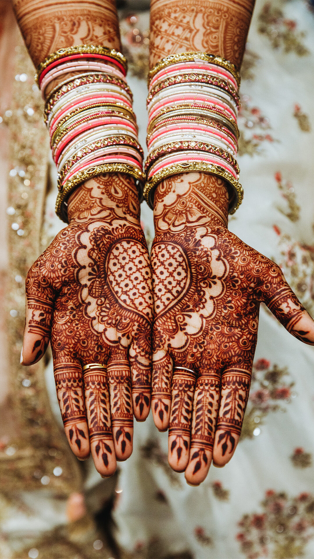 Bride proudly displaying her beautifully applied mehendi, a significant wedding tradition."